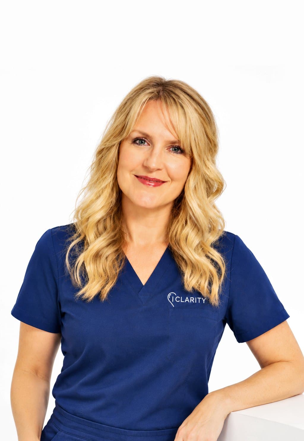 Michelle Christie, owner of Clarity, smiling in her navy Clarity scrubs