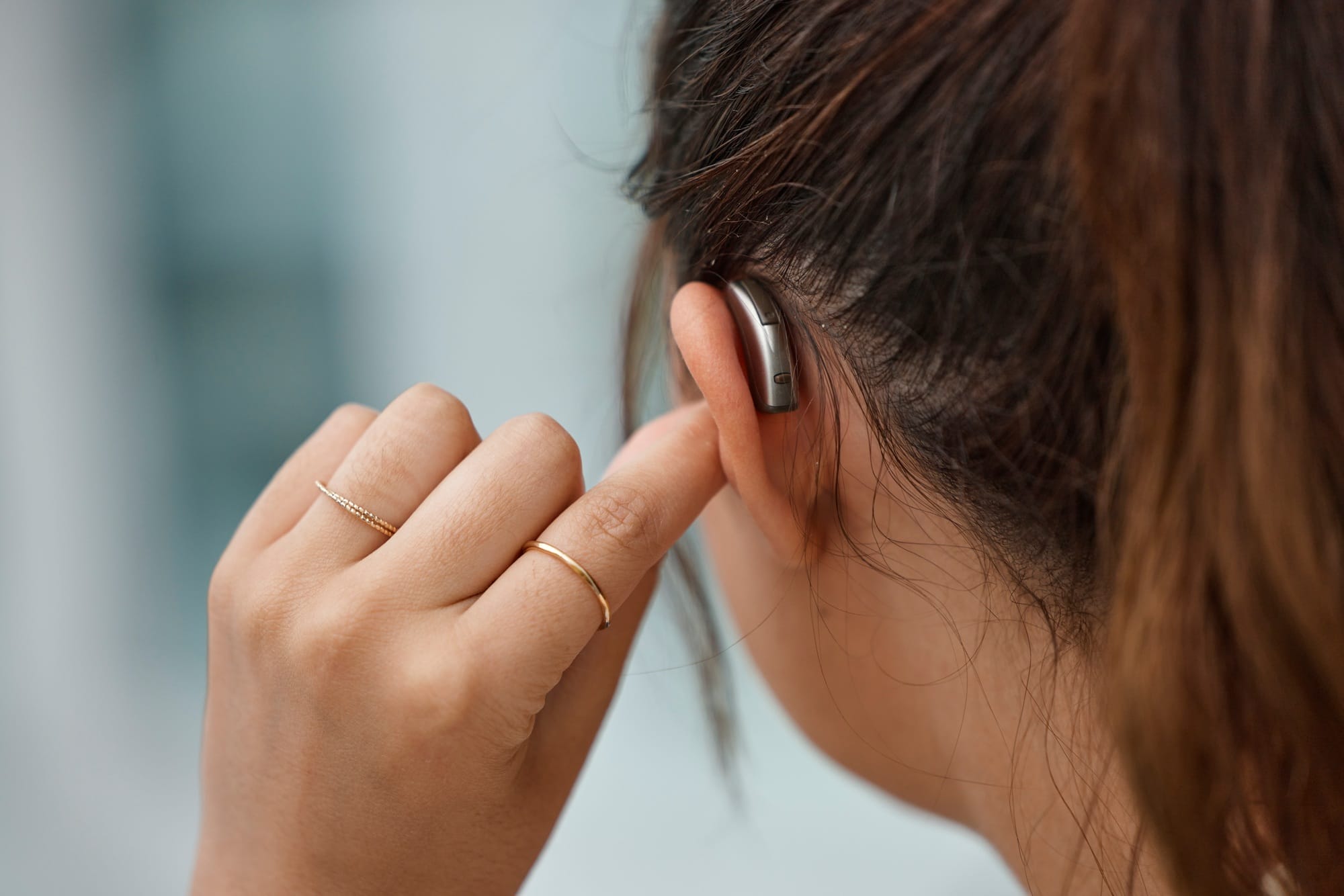 Hearing aid, closeup and ear of woman with disability from the back for medical support, listening